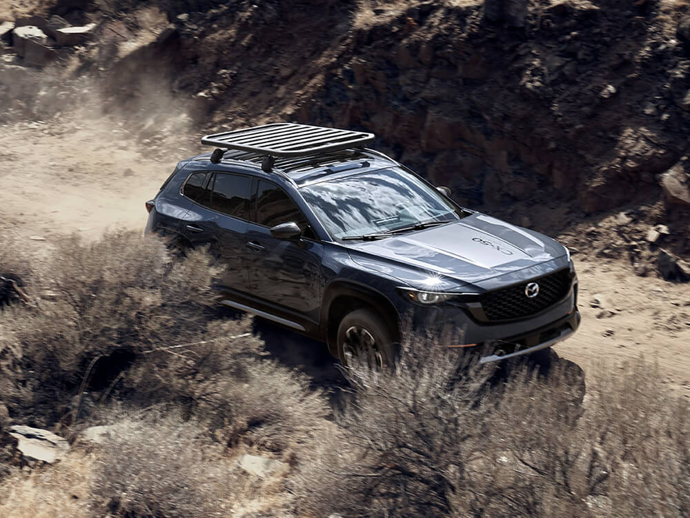 Overhead view of a Mazda CX-50 driving along a dirt trail